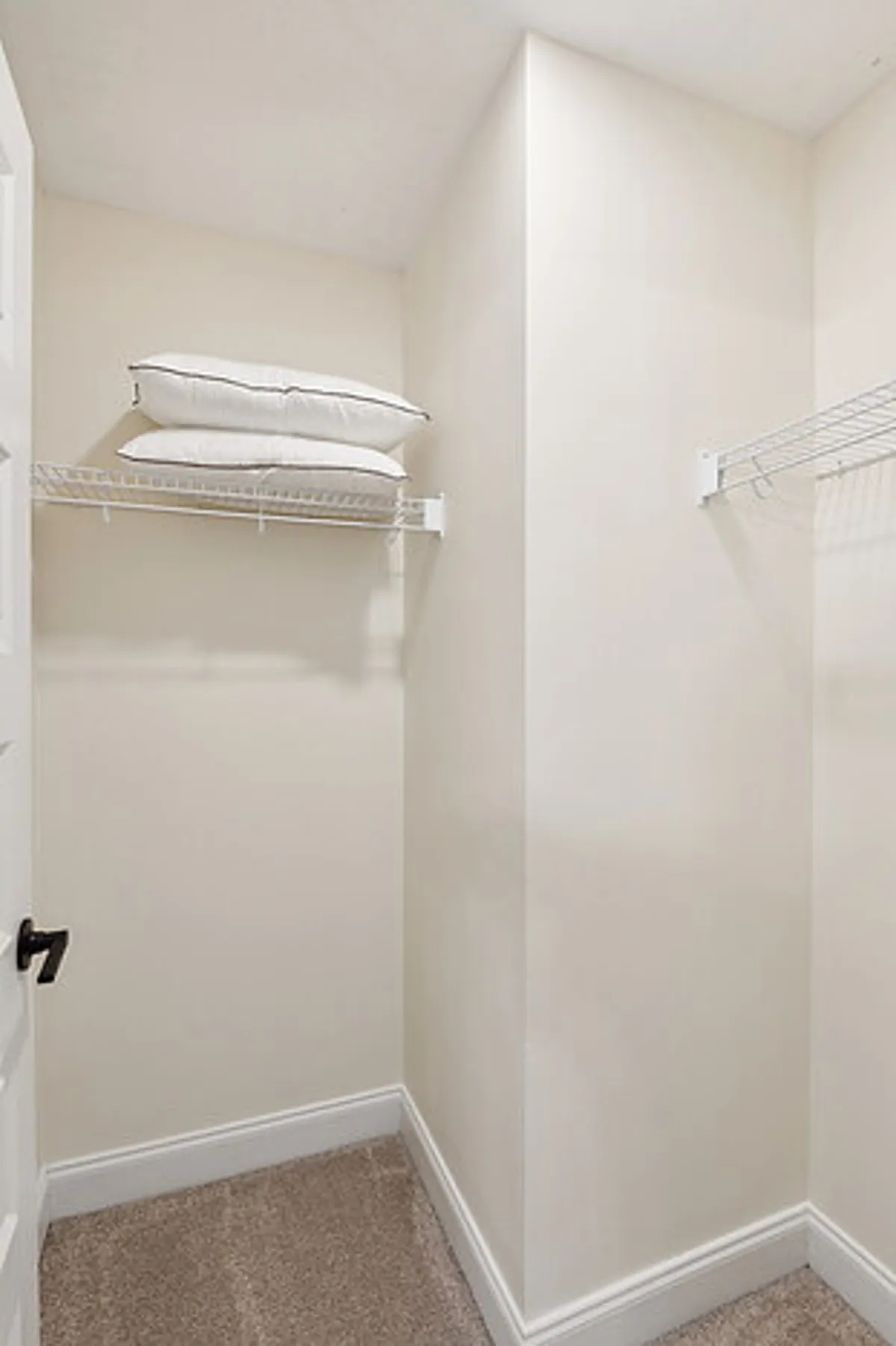 A minimalistic shelving area with neatly arranged pillows, providing a sense of organization and readiness for guests with varied needs.