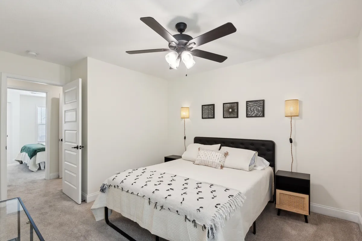Another tranquil bedroom featuring a comfortable bed, tasteful wall art, nightstands, and soft lighting fixtures. The mood is peaceful, suggesting a restful night's sleep and a welcoming place to recharge.